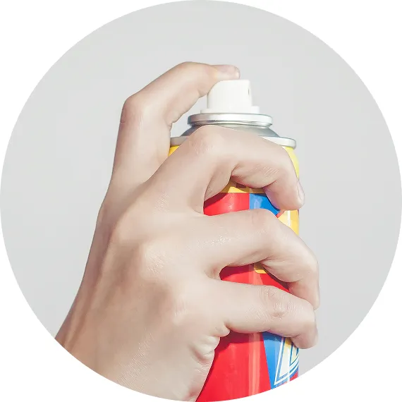 スプレー缶を握り、空中に向けて噴射しようとしている手元の様子