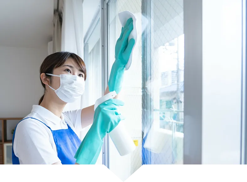 マスクを着用した清掃スタッフが窓を拭いている様子